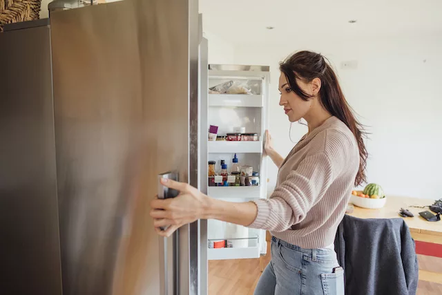 Woman looking in fridge while intermittent fasting